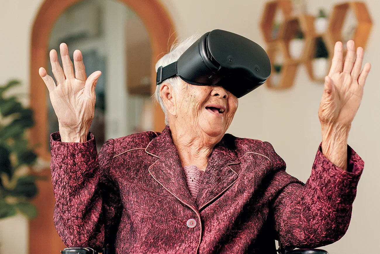 An elderly woman wearing a VR headset looking excited