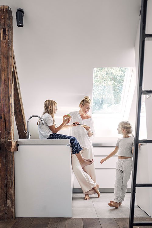 Mother talking with her two daughters in their kitchen