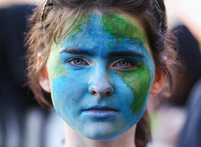Portrait of young person with face paint of the earth
