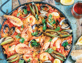 Seafood paella with muscles and shrimp in a large dish listing.png