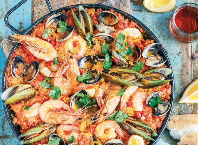 Seafood paella with muscles and shrimp in a large dish listing.png