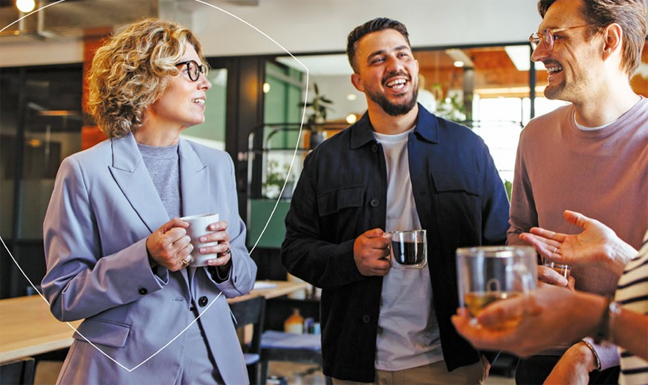 Some colleagues talking in an office with tea