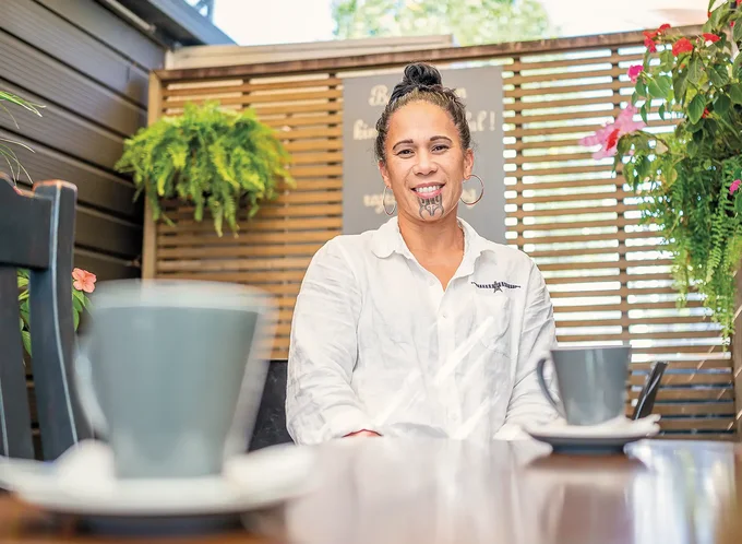 Woman at a table in a cafe - Aroha for the reo - listing