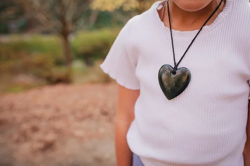 Woman in a white shirt wearing a heart necklace