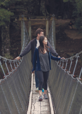 Two people crossing a bridge