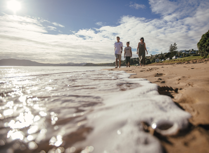 family walking along a beach in daylight listing