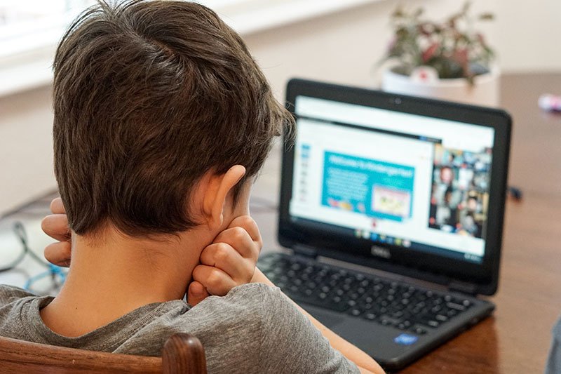 young boy watching his laptop